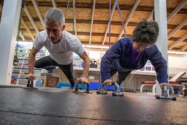 Adam Fawcett personal training a woman doing pushups together