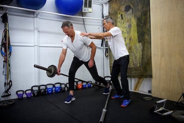 Adam Fawcett doing in person personal training with another man doing bent over rows