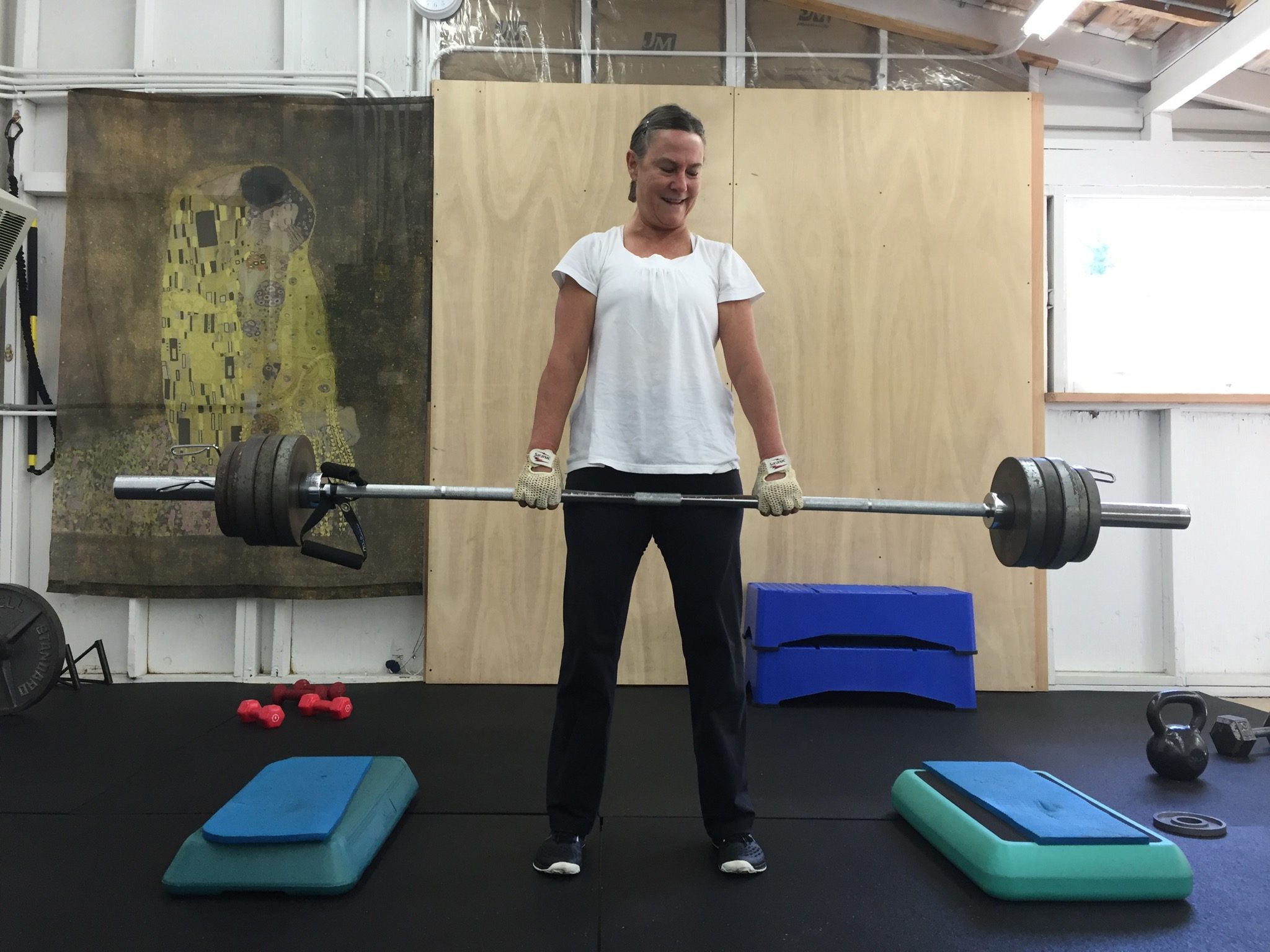 woman doing deadlifts with a barbell